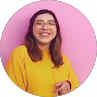 Smiling person in yellow sweater against pink background